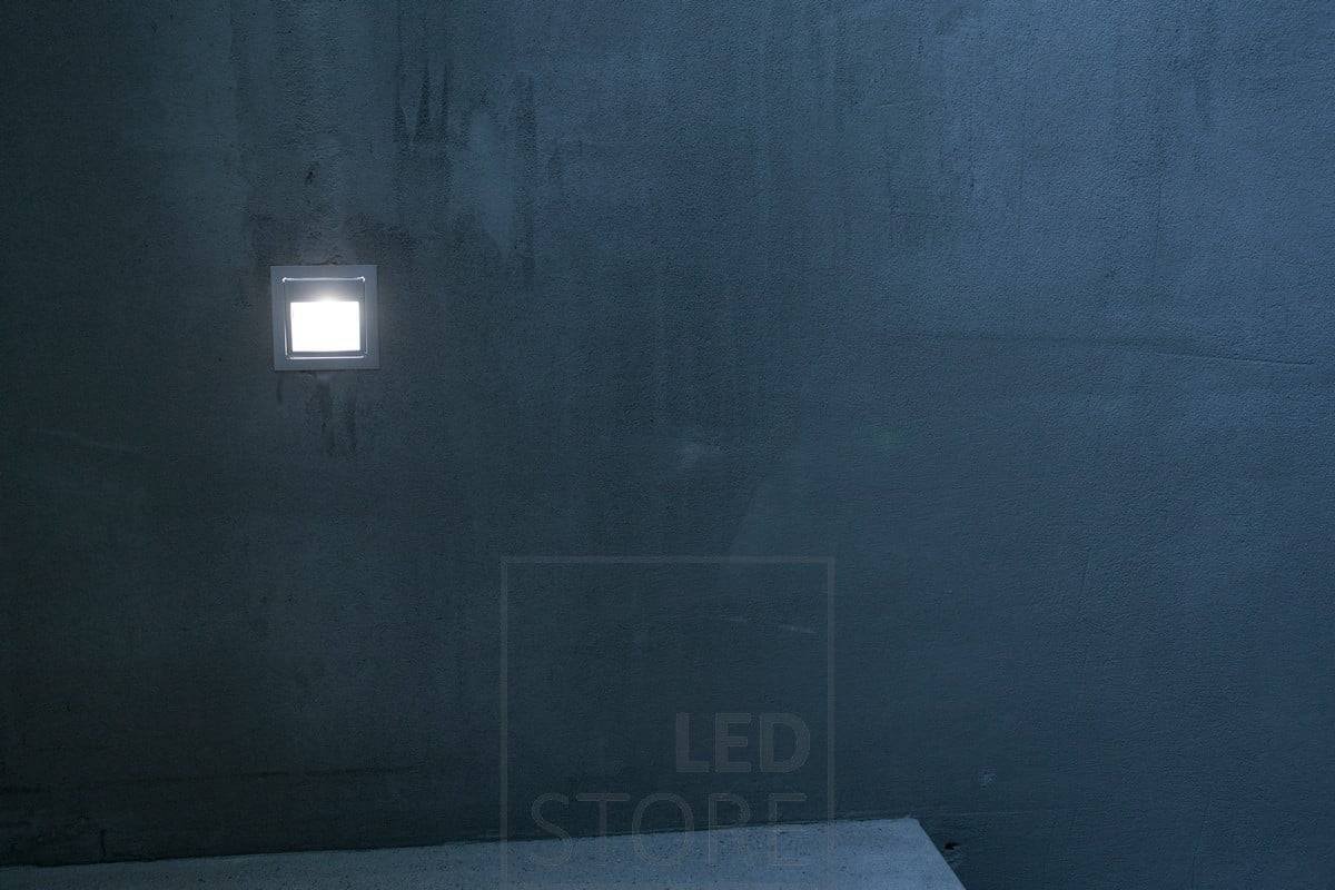 Luz suave y atmosférica de un aplique sobre el peldaño de una escalera